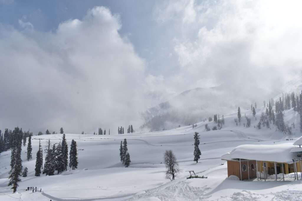 Kashmir in December (a snow covered mountain with a small cabin in the foreground)