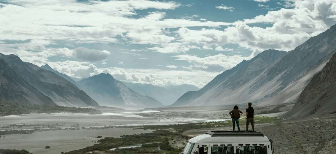 two person on top of white van while Ladakh trip- kashmir leh ladakh tour packages