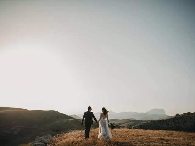 a bride and groom walking on a hill in Kashmir for photography