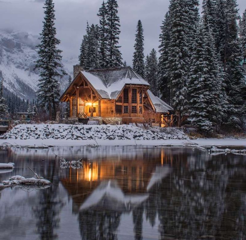 wooden house near pine trees and pond coated with snow during daytime in Pahalgam Kashmir -Kashmir cab service