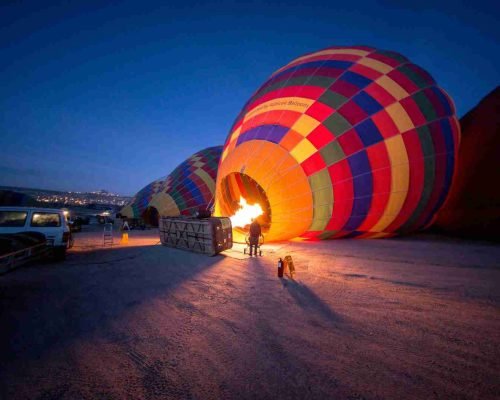 person standing near multicolored hot air balloon during night time in Srinagar, hot air balloon srinagar booking